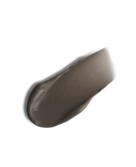 Beige-colored makeup product on a black background